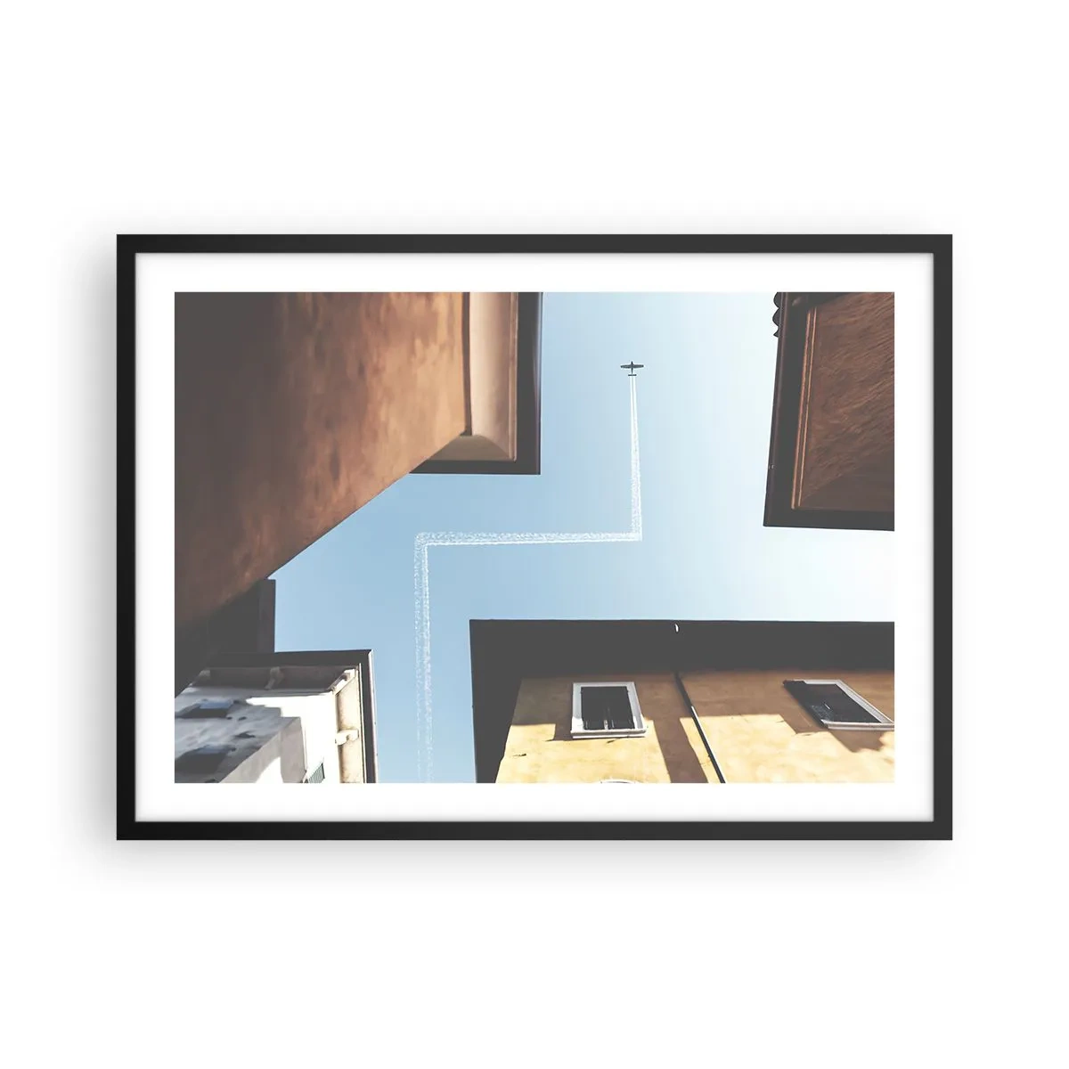 Poster in cornice nera - Vista dell'aereo e della sua scia nel cielo da una prospettiva stradale - 70x50cm - Sopra il labirinto urbano - Decorazione murale moderna per soggiorno e camera da letto ARTTOR