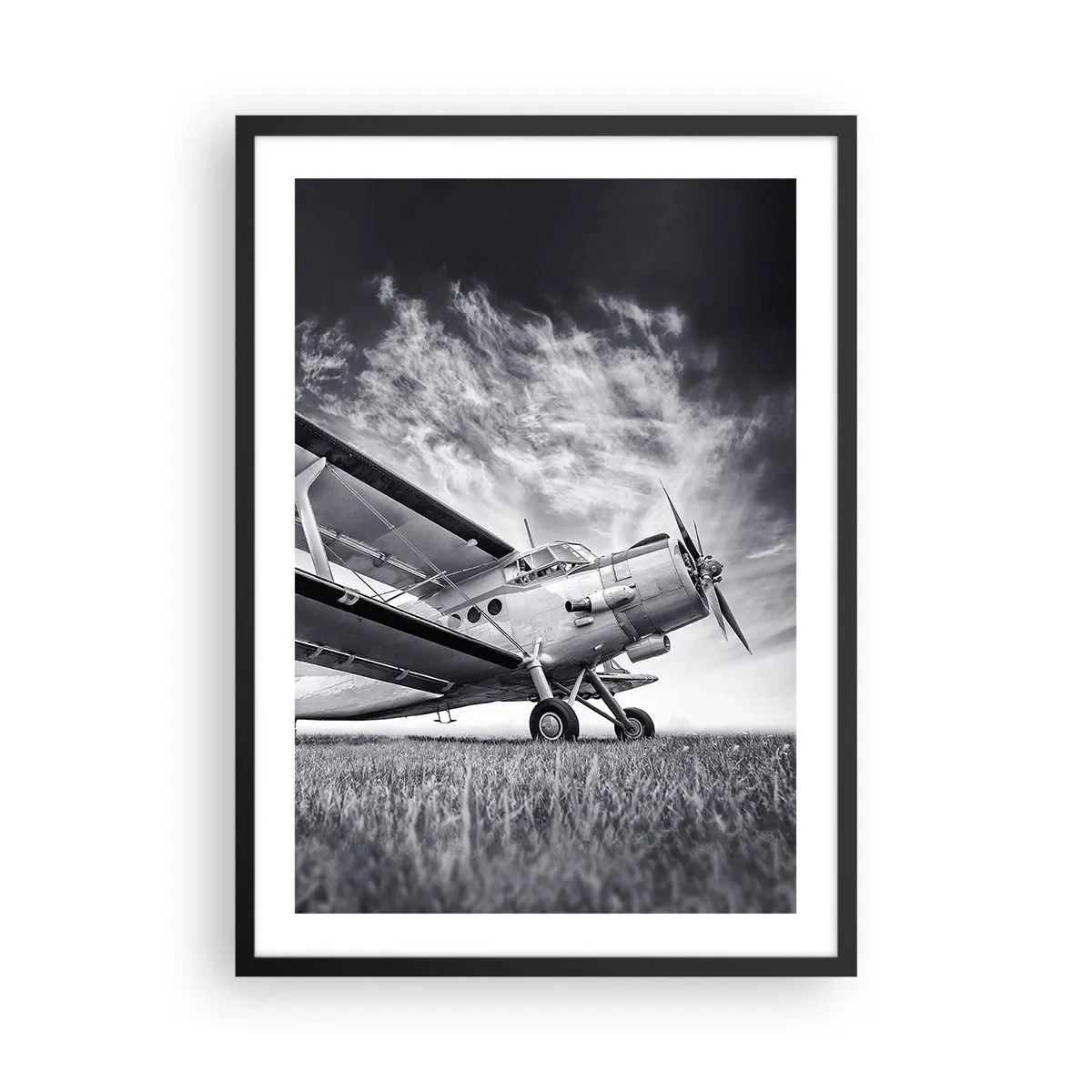 Poster in cornice nera - Un'immagine in bianco e nero di un aereo contro un cielo dinamico. - 50x70cm - Giramondo alato - Decorazione murale moderna per soggiorno e camera da letto ARTTOR
